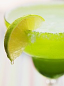 Lime wedge on cocktail glass with sugared rim