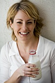 Young woman holding a bottle of milk in her hand