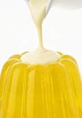 Pouring custard over lemon jelly