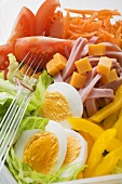 Mixed salad with ham and egg in plastic container