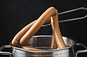 Lifting frankfurters out of a pan