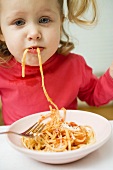 Small girl eating spaghetti