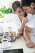 Young couple tasting fresh fruit tarts