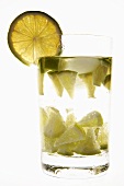 Mineral water with lime wedges, ice cubes & slice of lime