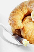 Croissants on a plate with knife and butter
