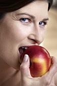 Frau beisst in einem Apfel