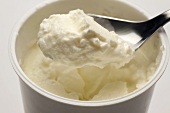 Schafmilch-Joghurt im Becher und auf Löffel