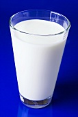 Ein Glas Milch vor blauem Hintergrund