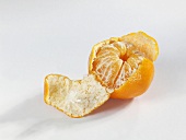 Eine Clementine zum Teil geschält