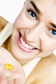 Woman holding a vitamin capsule on her hand