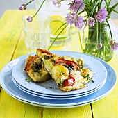 Two pieces of vegetable frittata on a pile of plates