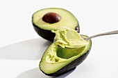 Hollowing out an avocado with a spoon