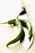 Two green chillies on a Chinese knife