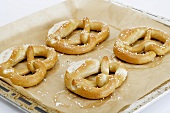 Four pretzels on a baking tray