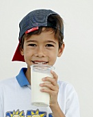 Junge hält ein Glas Milch in der Hand