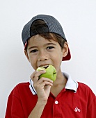 Junge beisst in einen Apfel