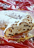 Stollen with icing sugar, partly sliced