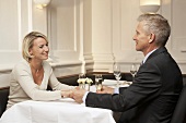 Flirtendes Ehepaar sitzt an einem Tisch im Restaurant