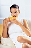 Woman in living room with cup of tea