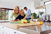 Family chopping vegetables in kitchen