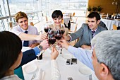 Toasting each other with red wine at a business lunch