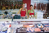 Two shop assistants behind fish counter in supermarket