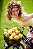 Woman with basket full on lemons on bicycle