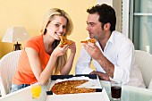 Man and woman eating pizza out of pizza box