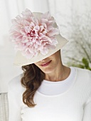 Woman in hat decorated with large flower