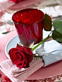 Place-setting with red glass and red rose