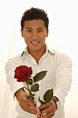 Asiatischer Mann mit roter Rose