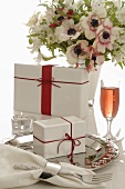 Vase of flowers, gifts and glass of sparkling wine
