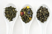 Three different sorts of tea in porcelain spoons (overhead)