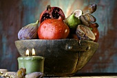 Pomegranates, figs and dates in wooden bowl