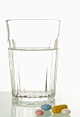 Glass of water and various tablets