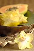 Slices of carambola and papaya in wooden bowl