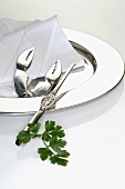 Lobster crackers and lobster fork on a silver plate