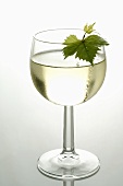 Glass of white wine with vine leaf
