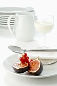 Figs and redcurrants on plate, glass of milk