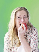 Frau beisst in roten Apfel
