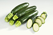 Several whole and one sliced courgette