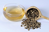 Cup of tea with dried black cohosh root and tea strainer