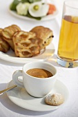 A cup of espresso, apple juice and pastries