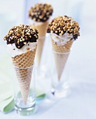 Three cones of stracciatella ice cream with chocolate & nuts