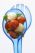 Cherry tomatoes with mozzarella and basil on salad servers