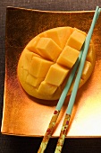 Fresh mango, cut into cubes, with chopsticks