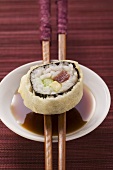Maki sushi with tuna, cucumber and avocado over soy sauce 