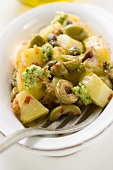 Spicy fried potatoes with olives, pesto and capers