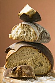 Rustic bread, two loaves with pieces cut off in a pile