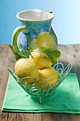 Fresh lemons with leaves in wire basket